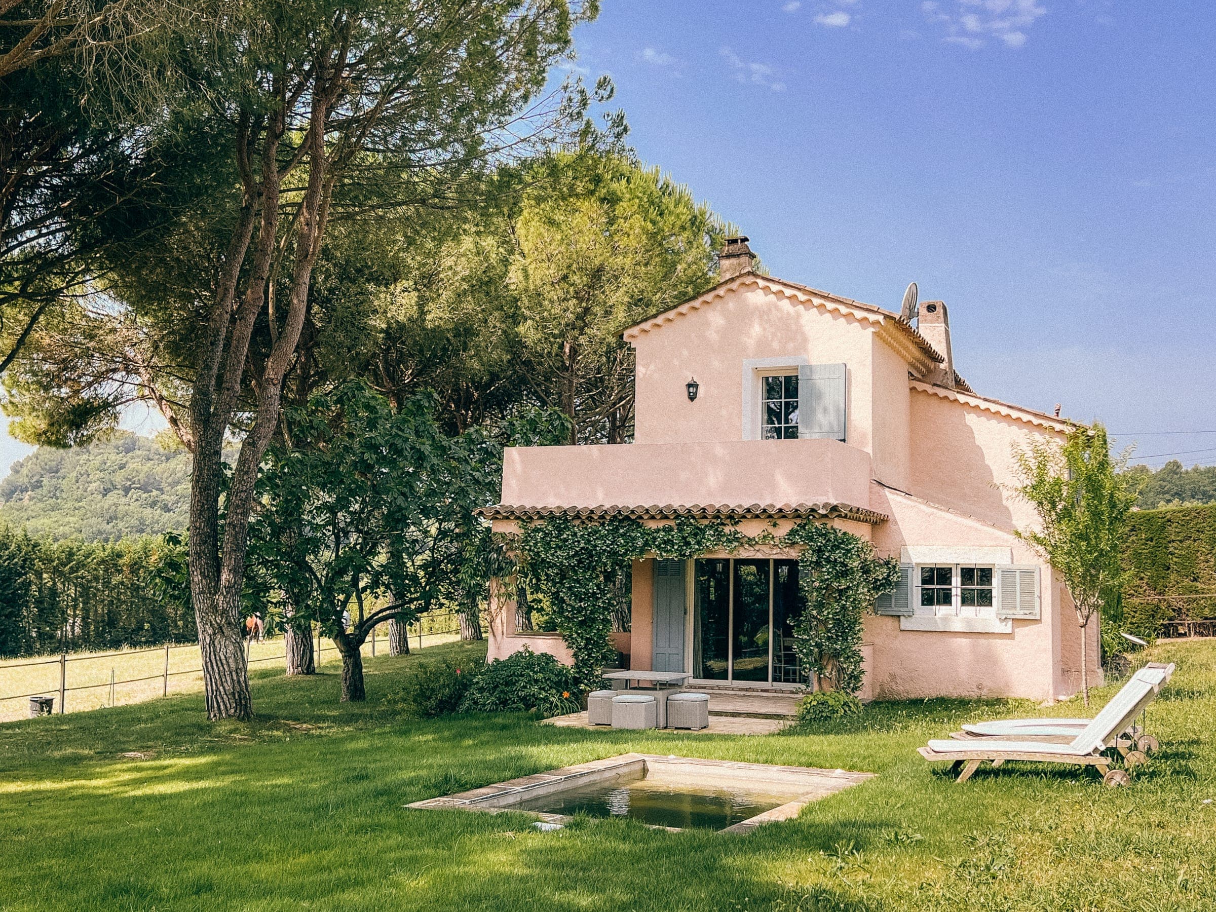 La maison provençale rose du Mas Rose parmi les pins, avec pelouse et transats